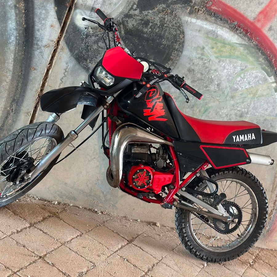 Tampa vermelha com aro preto montada numa Yamaha DT50 de um cliente